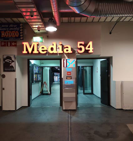 Straight through the Media 54 doors and to the end of the corridor. Then downstairs to floor 0.
