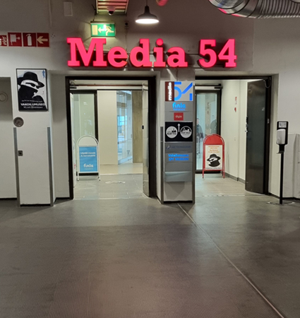 Straight through the Media 54 doors and to the end of the corridor. Then downstairs to floor 0.